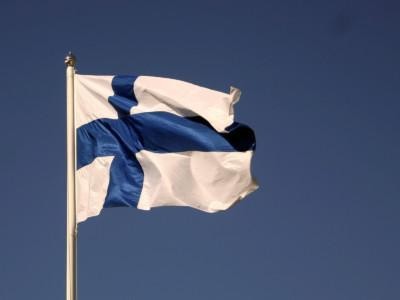 Suomen lippu liehuu salossa sinitaivaan alla.