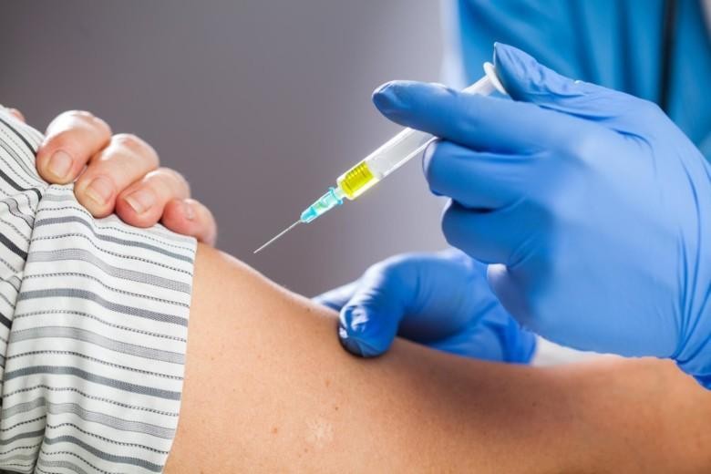 Henkilö saa rokotteen käsivarteen.