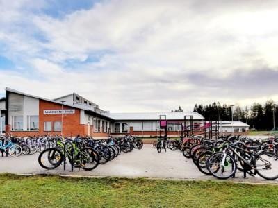 Loukinaisten koulu ja sen täynnä polkupyöriä olevat pyörätelineet.