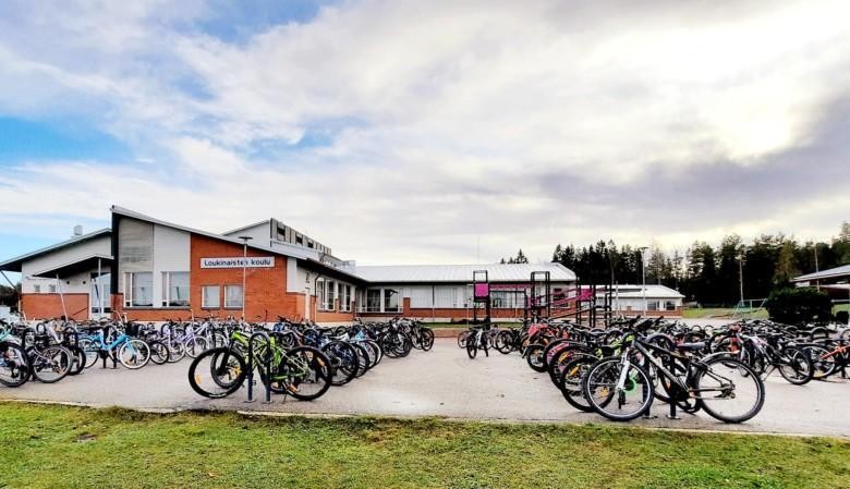 Loukinaisten koulu ja sen täynnä polkupyöriä olevat pyörätelineet.