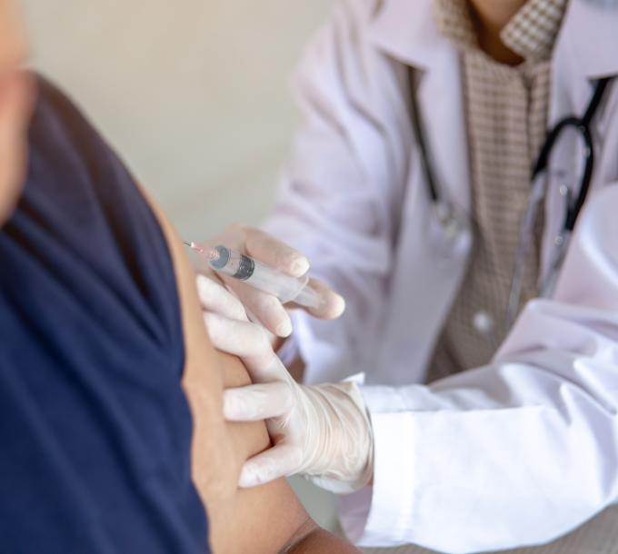 Sairaanhoitaja antaa rokotuksen henkilön käsivarteen.