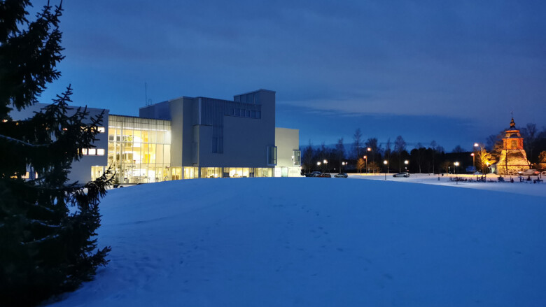 Liedon kaupungintalo puiston suunnasta. Sininen aamuhämärä ja valkeat hanget.