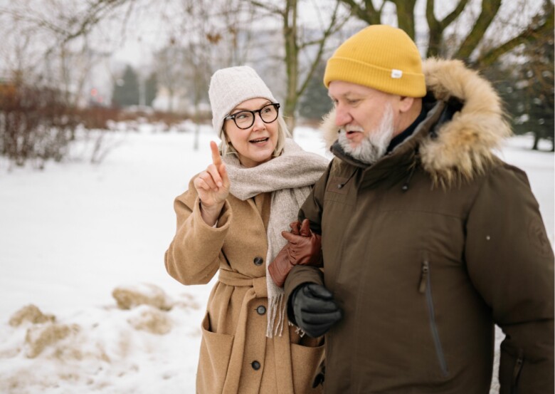 Seniorimies ja -nainen kävelemässä talvella ulkona.